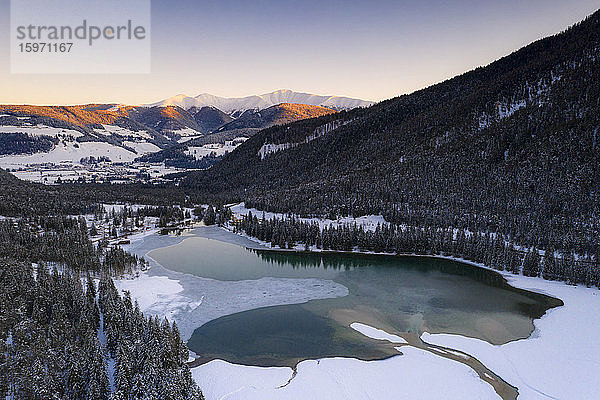 Sonnenaufgang über dem Dorf Toblach und dem zugefrorenen See  Pustertal  Dolomiten  Provinz Bozen  Südtirol  Italien  Europa