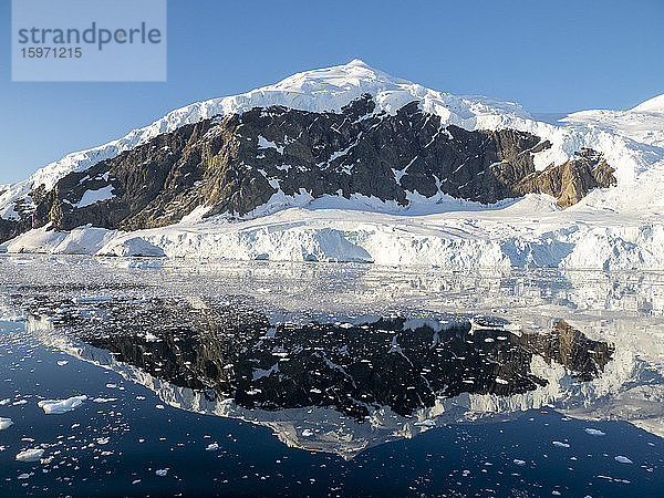 Eisbedeckte Berge spiegeln sich im ruhigen Wasser von Neko Harbor  Antarktis  Polarregionen