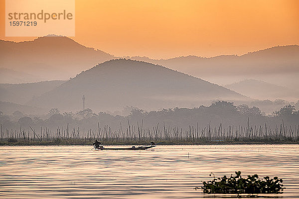 Junger Fischer mit Netz bei Sonnenaufgang  Inle-See  Shan-Staat  Myanmar (Burma)  Asien