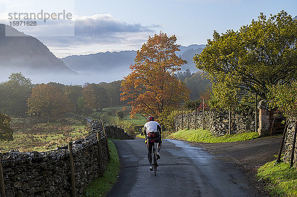 Radfahrer auf der Spur im Herbst  Borrowdale  Lake-District-Nationalpark  UNESCO-Weltkulturerbe  Cumbria  England  Vereinigtes Königreich  Europa