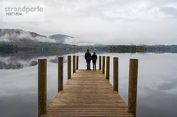 Ein Paar steht am Ashness Pier Landing Jetty  Derwentwater  Keswick  Lake District National Park  UNESCO-Weltkulturerbe  Cumbria  England  Vereinigtes Königreich  Europa