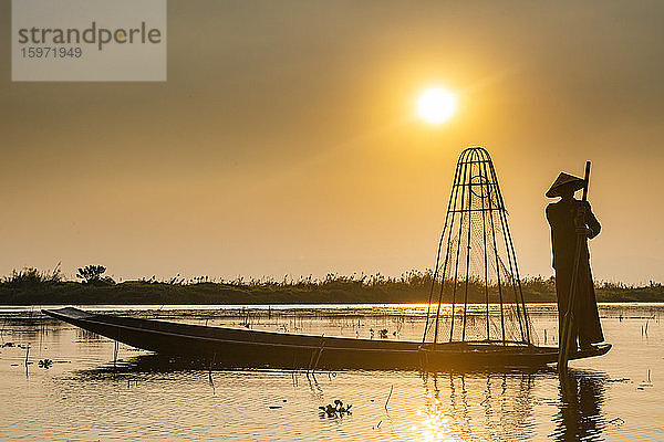 Fischer am Inle-See mit traditionellem konischen Intha-Netz bei Sonnenuntergang  Fischernetz  Beinruderstil  Intha-Volk  Inle-See  Shan-Staat  Myanmar (Burma)  Asien