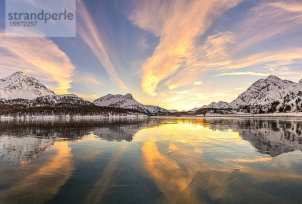 Farben des Sonnenuntergangs  reflektiert auf der eisigen Oberfläche des Silsersees  Engadin  Graubünden  Schweiz  Europa