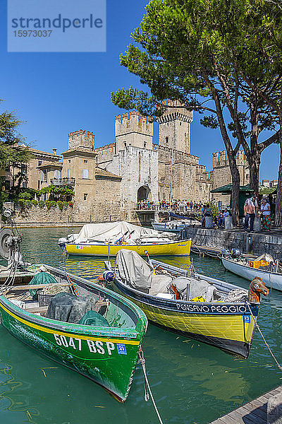 Blick auf Boote und Castello di Sirmione an einem sonnigen Tag  Sirmione  Gardasee  Brescia  Lombardei  Italienische Seen  Italien  Europa