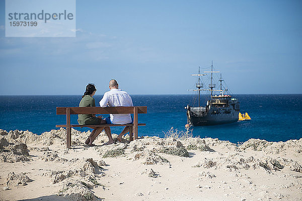 Ehepaar saß mit Blick auf ein Piraten-Themenschiff  Cape Greco  Protaras  Zypern  Mittelmeer  Europa