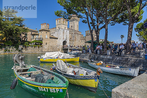 Blick auf Boote und Castello di Sirmione an einem sonnigen Tag  Sirmione  Gardasee  Brescia  Lombardei  Italienische Seen  Italien  Europa