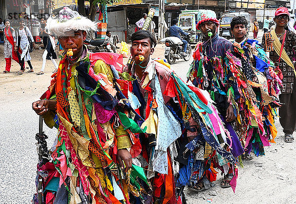 Adivasi-Dorfbewohner feiern Holi  indem sie sich in bunte Lumpen kleiden und andere Dörfer besuchen  Gujarat  Indien  Asien