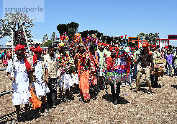 Adivasi-Stammesangehörige  Gesichter und Körper geschmückt  mit kunstvoller Kopfbedeckung  tanzen zum Holi-Fest  Kavant  Gujarat  Indien  Asien