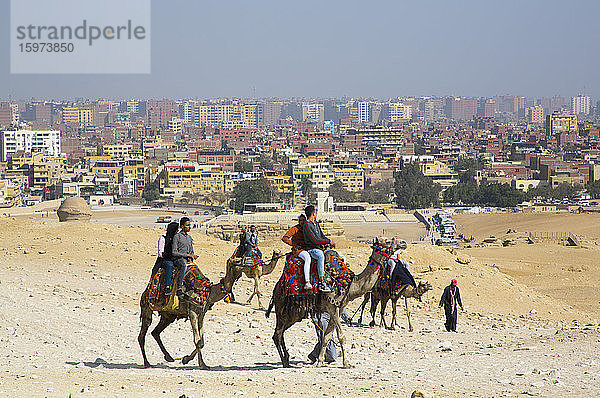 Touristen auf Kamelen bei den Großen Pyramiden von Gizeh  UNESCO-Weltkulturerbe  Gizeh  Ägypten  Nordafrika  Afrika