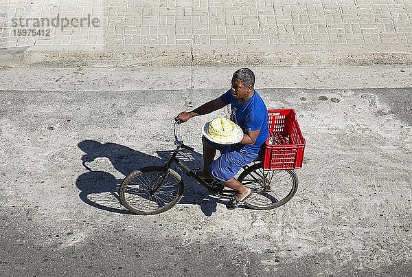 Mann auf einem Fahrrad  der versucht  einen Kuchen zu verkaufen  Santiago de Cuba  Kuba  Mittelamerika