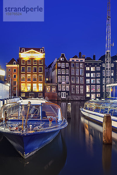 Niederlande  Nordholland  Amsterdam  Ausflugsboote im Hafen der Altstadt bei Nacht