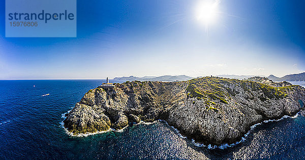 Spanien  Mallorca  Cala Ratjada  Blick aus dem Hubschrauber auf die Sonne  die über den Küstenklippen und dem Leuchtturm Far de Capdepera im Sommer scheint