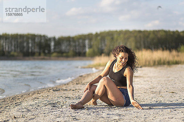Glückliche junge Frau beim Entspannen am Strand