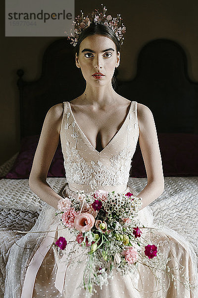 Junge Frau im Hochzeitskleid mit Blumenstrauß