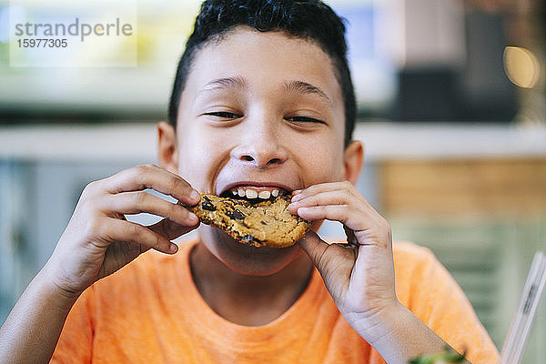 Porträt eines Jungen  der einen frischen Keks im Restaurant genießt