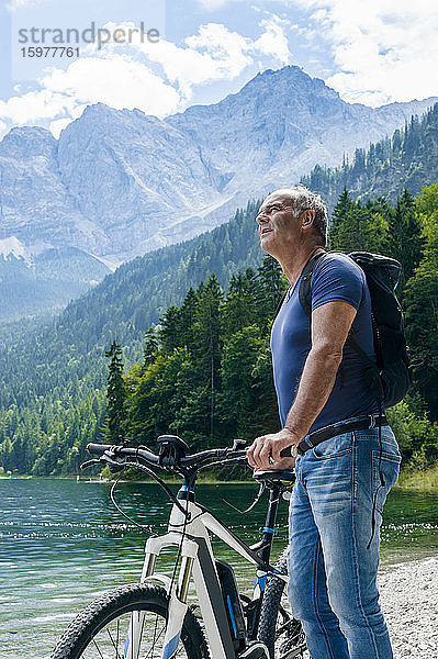 Älterer Mann mit E-Bike am Eibseeufer