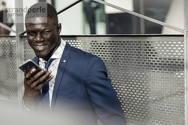 Porträt eines lächelnden Geschäftsmannes mit Mobiltelefon