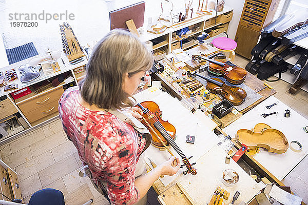 Geigenbauerin bei der Arbeit in ihrer Werkstatt