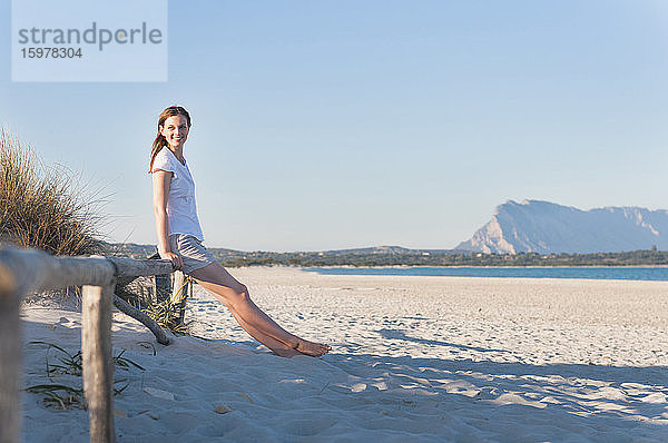 Lächelnde Frau beim Entspannen am Strand  Sardinien  Italien