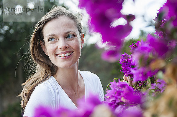 Porträt einer glücklichen Frau mit lila Blüten  Sardinien  Italien