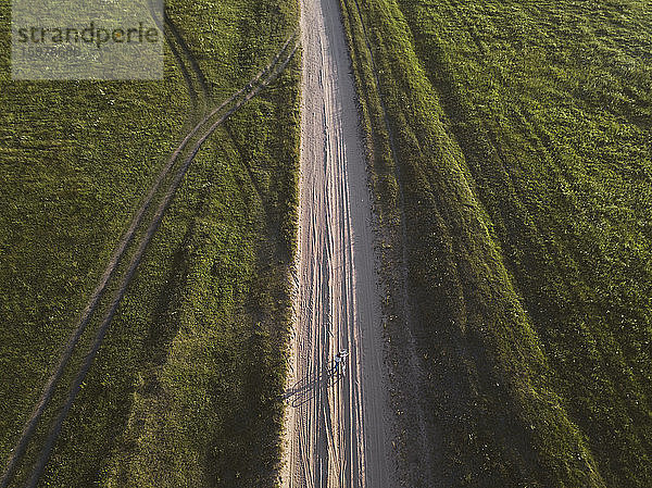 Luftaufnahme einer Frau mit Fahrrad auf einem unbefestigten Weg inmitten der Landschaft  Tichwin  Russland