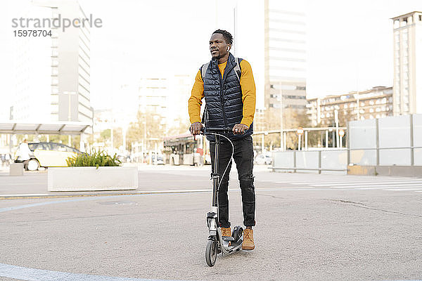 Junger Mann fährt E-Roller in der Stadt