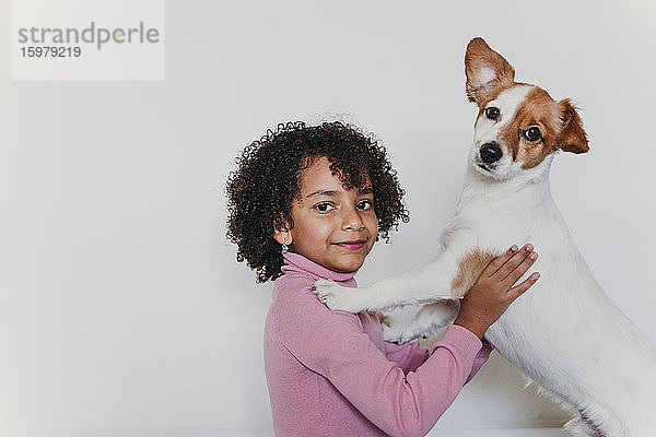 Porträt eines lächelnden kleinen Mädchens mit ihrem Hund