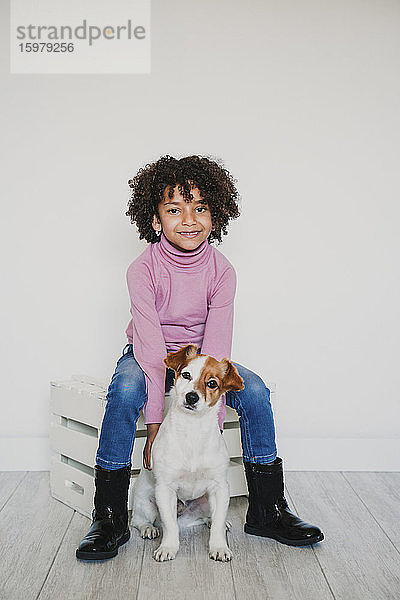 Porträt eines lächelnden kleinen Mädchens und ihres Hundes