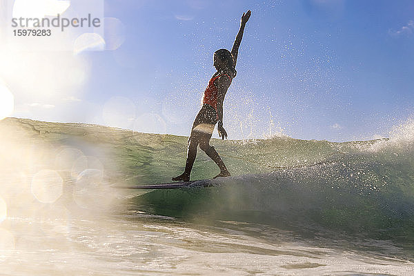 Weibliche Surferin balanciert auf Surfbrett