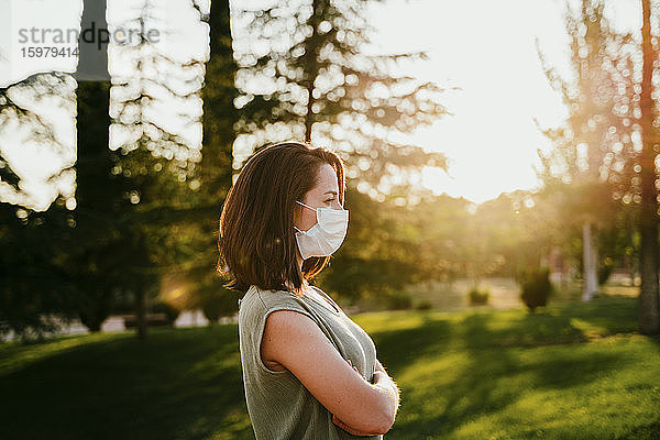 Nachdenkliche Frau mit Schutzmaske in der Natur