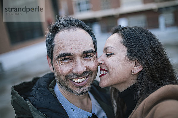 Glücklicher Mann nimmt Selfie mit Frau im Freien