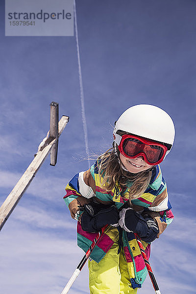 Niedriger Blickwinkel eines aufgeregten Mädchens beim Skifahren gegen den Himmel im Winter am Spitzingsee  Bayern  Deutschland