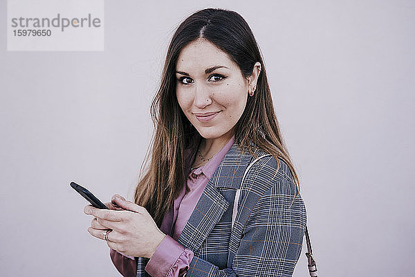 Porträt einer lächelnden Frau mit Smartphone