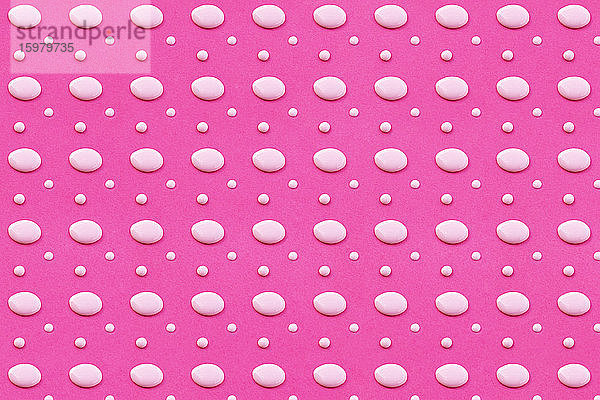 Muster aus weißen Flüssigkeitstropfen auf leuchtend rosa Hintergrund