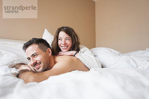Nachdenkliches junges Paar liegt zu Hause im Bett