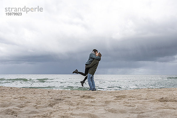 Russland  Kaliningrad Oblast  Zelenogradsk  Erwachsenes Paar küsst sich am Sandstrand der Ostsee