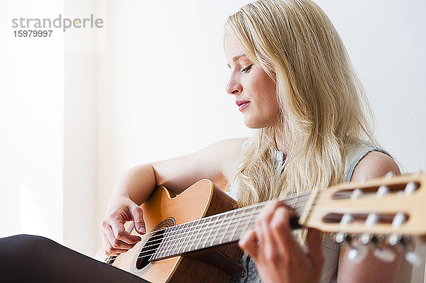 Porträt einer blonden Frau  die Gitarre spielt