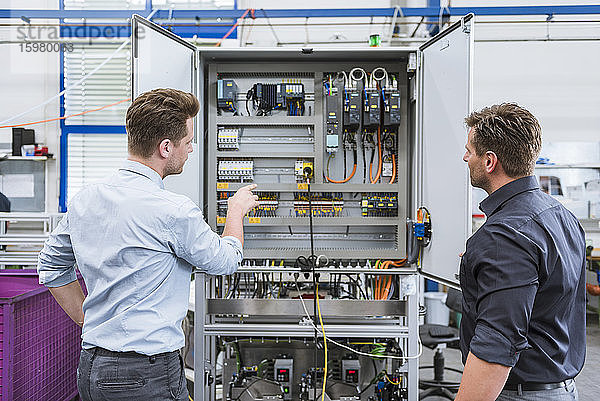 Zwei Techniker arbeiten an einem Schaltkreis in einer Fabrik