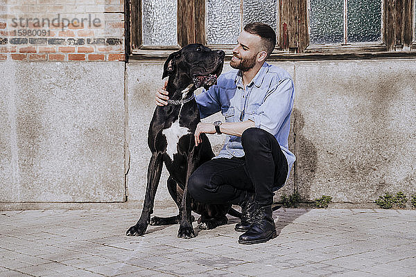 Lächelnder Mann mit seinem Hund im Freien