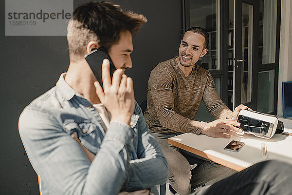 Junge Geschäftsleute  die im Büro zusammenarbeiten und miteinander telefonieren