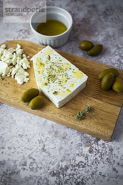 Schneidebrett mit Feta-Käse und Oliven