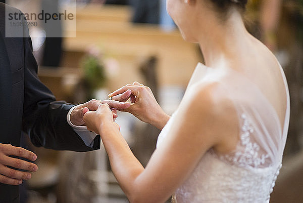 Die Braut trägt den Ehering zum Bräutigam  während sie in der Kirche steht