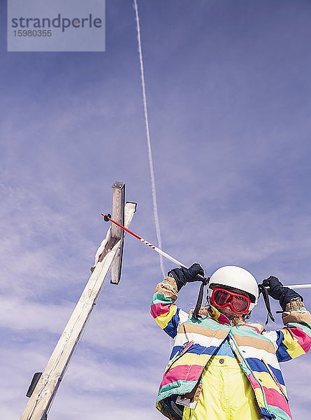 Tiefblick auf ein Mädchen in Skikleidung mit Skiern am Spitzingsee  Bayern  Deutschland