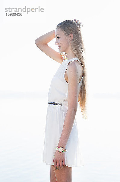 Porträt einer jungen Frau  die vor einem See steht