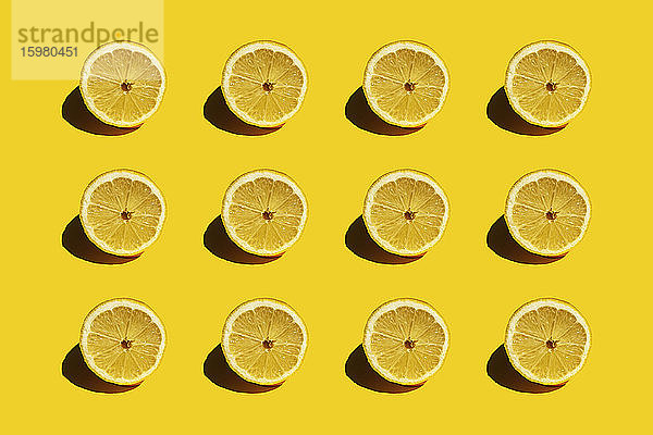 Muster aus frischen halbierten Zitronen vor gelbem Hintergrund