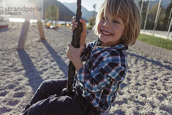 Fröhlicher Junge beim Schwingen am Seil am Achensee  Bundesland Tirol  Österreich