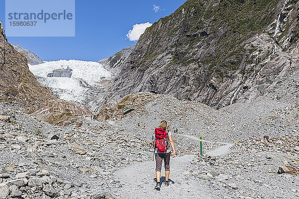 Neuseeland  Westland District  Franz Josef  Rucksacktouristin beim Wandern im Franz Josef Gletscher