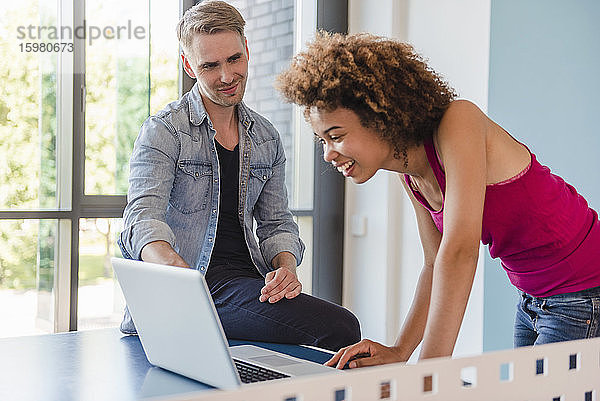 Junge Geschäftsleute bei einem Treffen in einem modernen Loft-Büro  mit Laptop