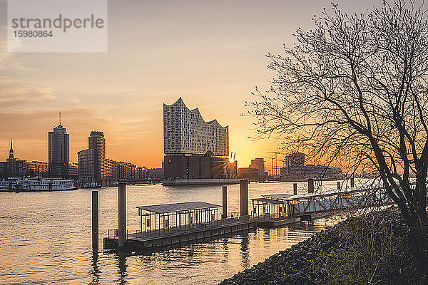 Deutschland  Hamburg  Leerer Hafen am Elbufer bei Sonnenaufgang mit Elbphilharmonie im Hintergrund