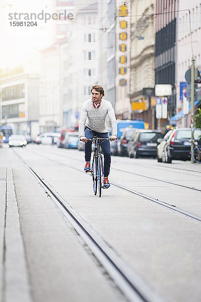 Junger Mann fährt Fahrrad in der Stadt